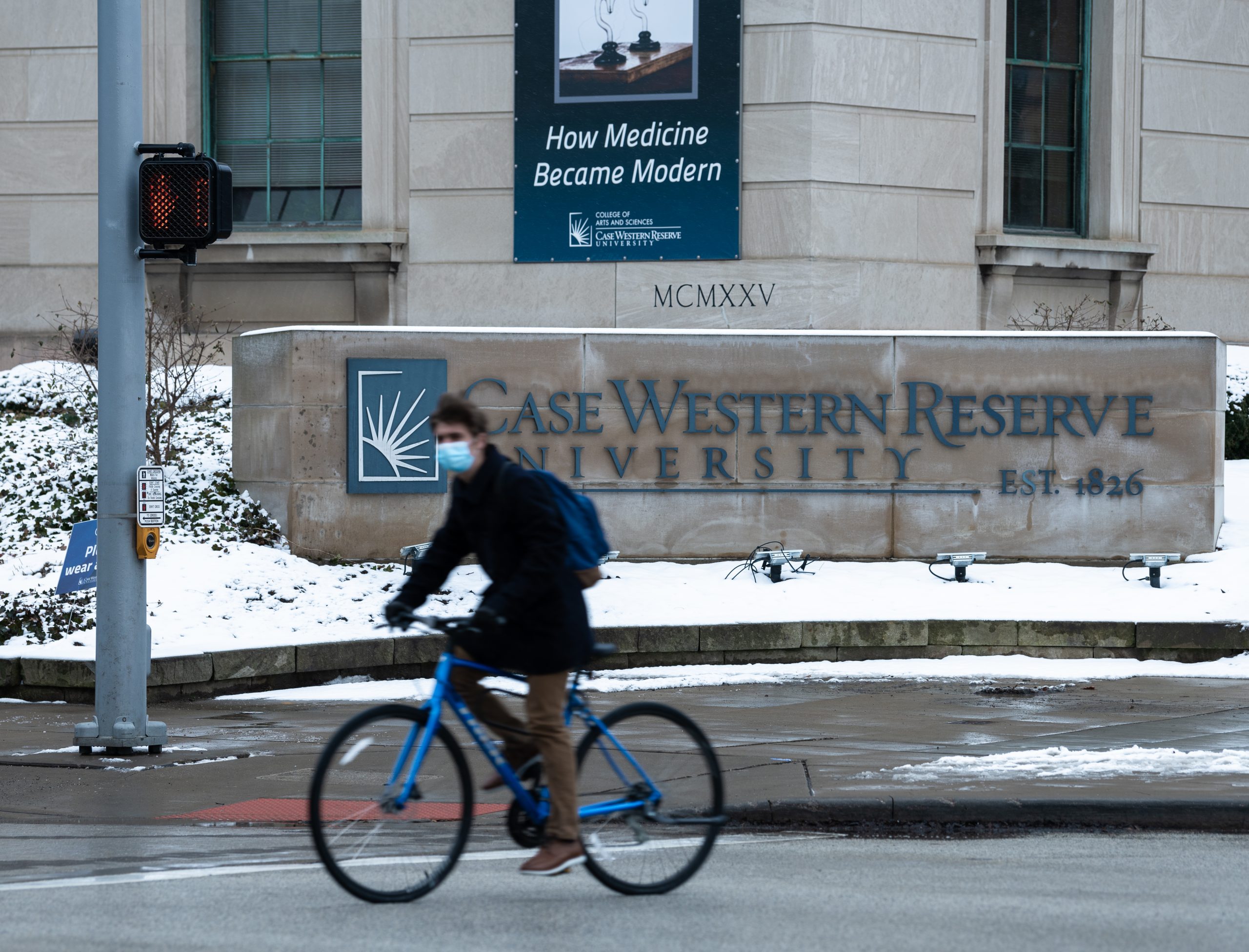 A person bikes past the Case Western Reserve University campus