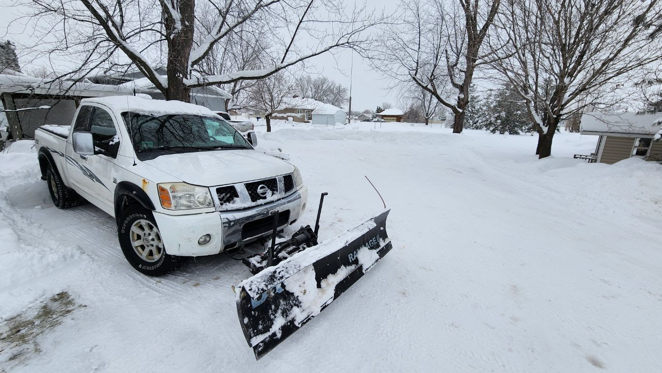 A white pickup truck with a snowplow attachment